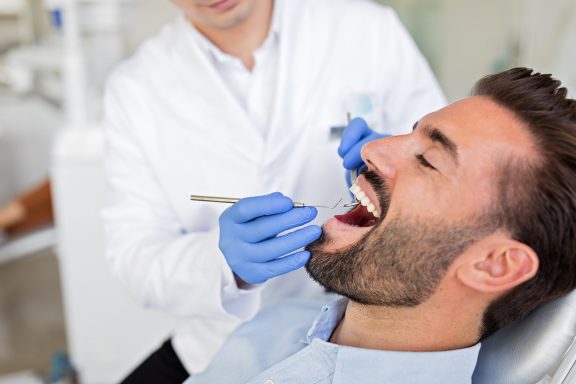 man receives an oral exam for wisdom teeth removal services Calgary